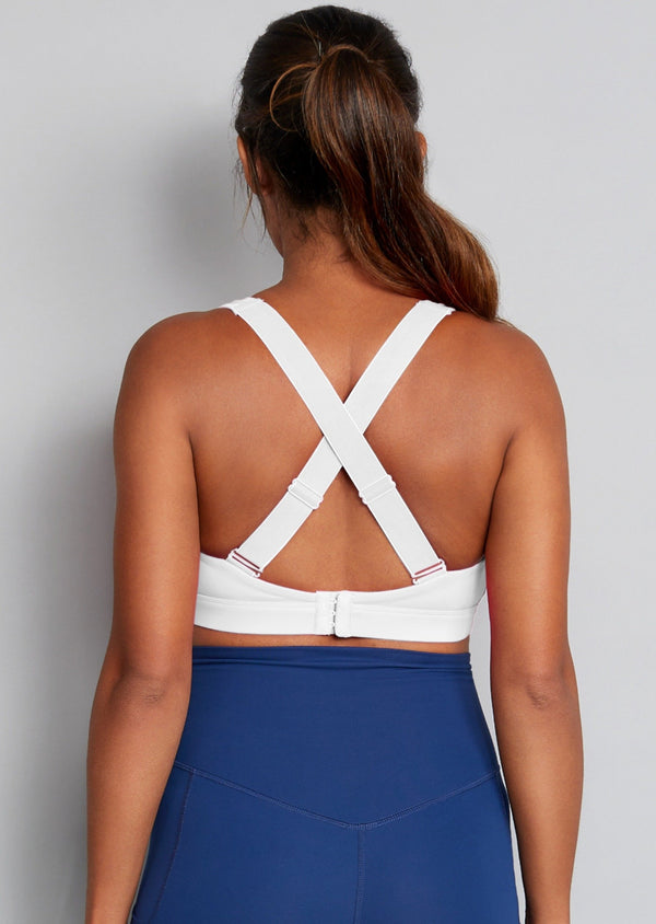 Back straps of white nursing sports bra with blue leggings.